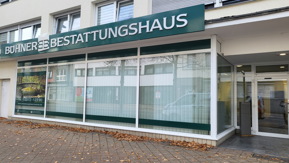 Fassade des Bestattungshauses Bühner GmbH in Hemer mit Firmenschild und großen Fenstern – seriös und einladend.
