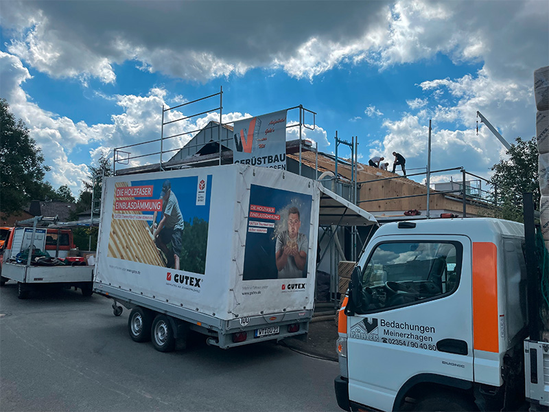 Firmenfahrzeuge der Köhler Bedachungen Meinerzhagen im Einsatz auf einer Baustelle, transportieren Material für Dachsanierung, Reparaturen und Wartungsarbeiten..