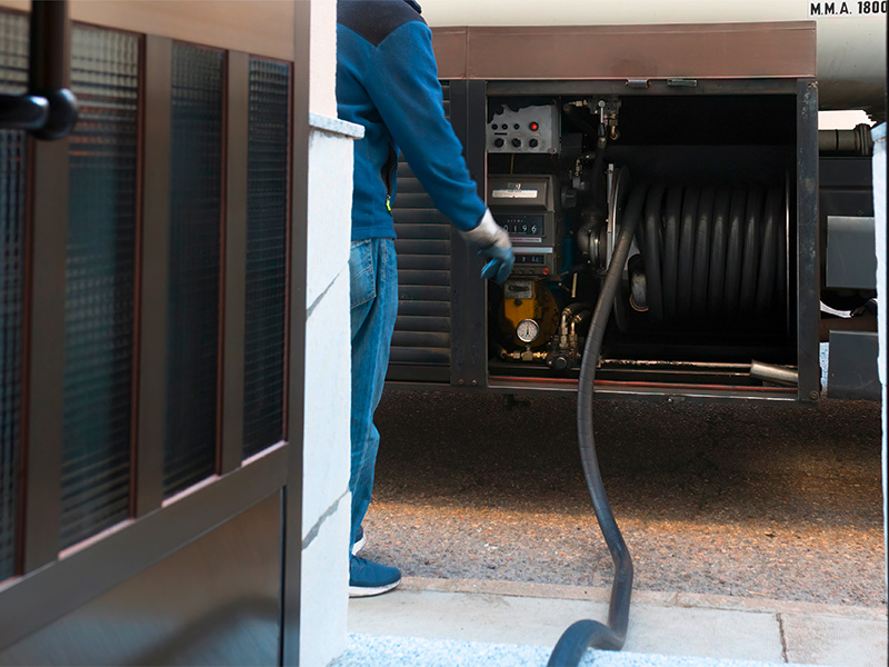 Lieferwagen mit Schlauch an Haus in Plettenberg bei der Heizöl Zufuhr, zeigt pünktliche Versorgung und Winterbereitschaft.