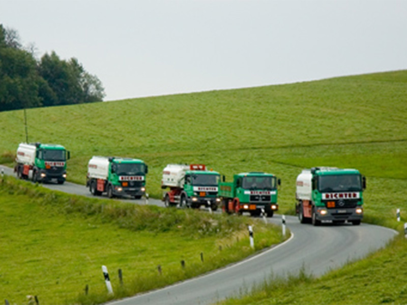 Mehrere Tankwagen von Richter Mineralöl fahren auf Landstraße, um Heizöl zuverlässig zu Kunden zu liefern