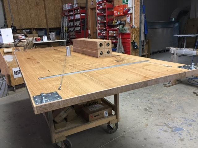 Schreiner bearbeitet einen Tisch aus Massivholz in Werkstatt – Fertigung in eigener Werkstatt von Team Schreinermeister