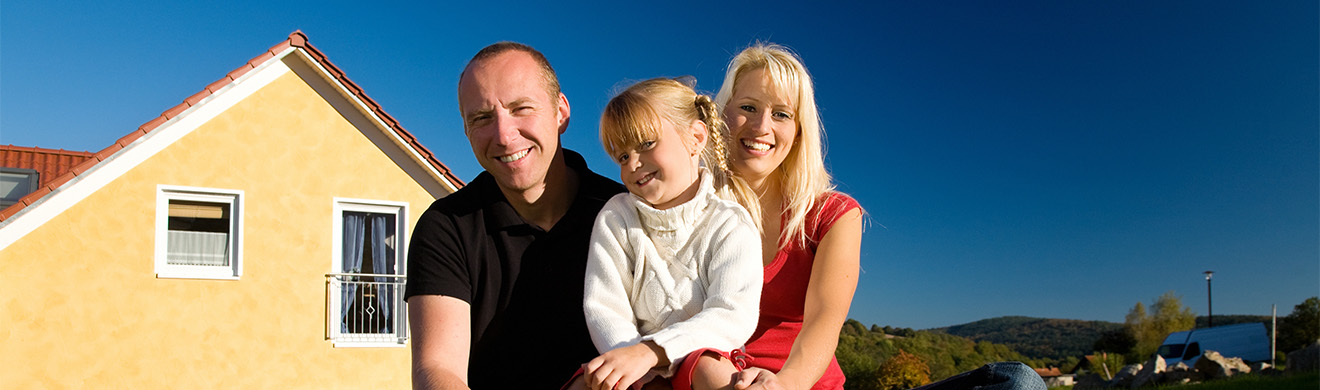Glückliche Familie vor ihrem Eigenheim, Symbol für langfristige Sicherheit und erfolgreiche Altersvorsorge in Arnsberg.