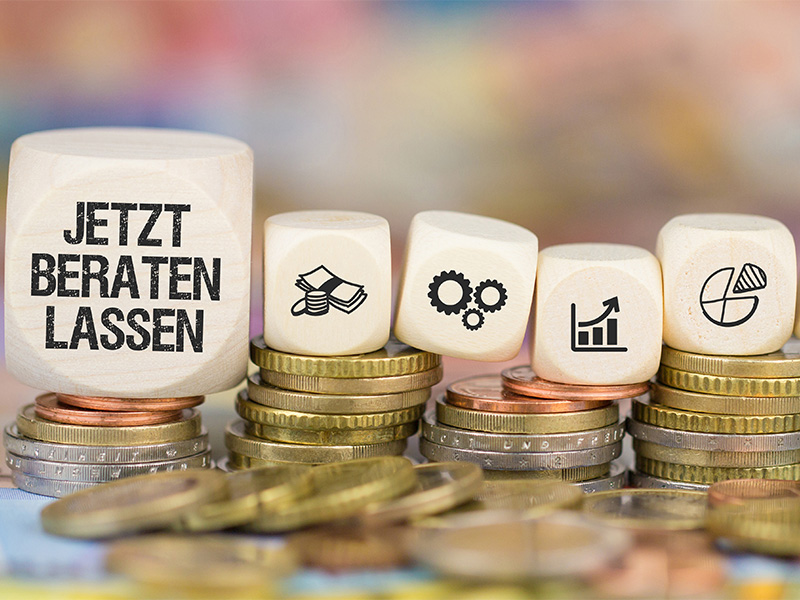 Münzstapel mit Symbolen wie Haus, Herz und Briefumschlag – Sinnbild für betriebliche Altersvorsorge in Arnsberg.