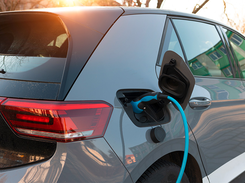 Ein E-Auto wird an einer Wallbox direkt am Haus aufgeladen.